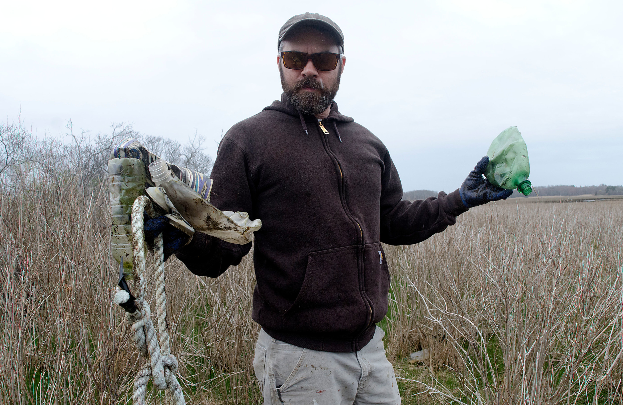 Tanner Steeves of DEM holds up trash that he found during the restoration.