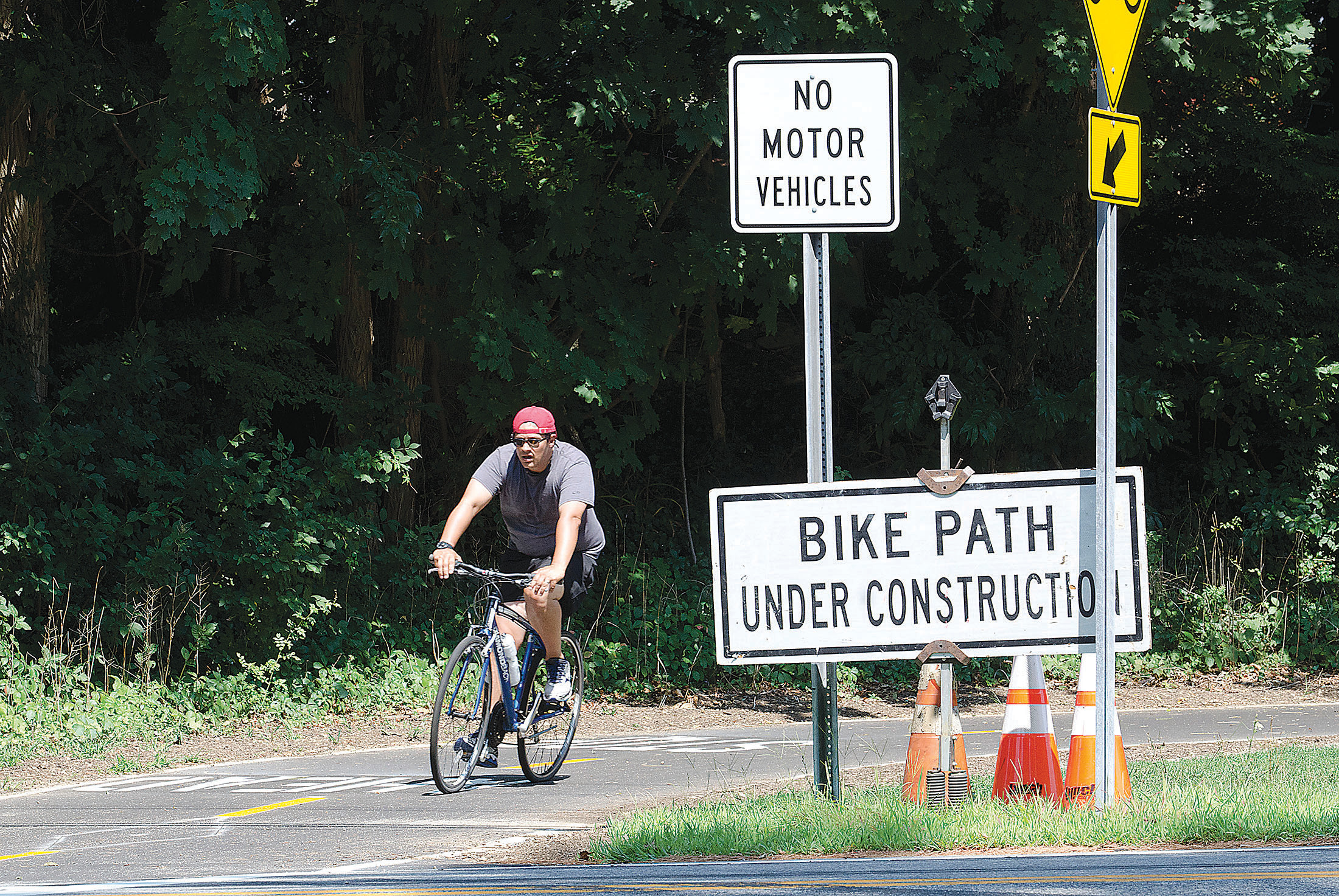 A bicyclist rides the East Bay Bike Path approaching the intersection with Middle Highway.