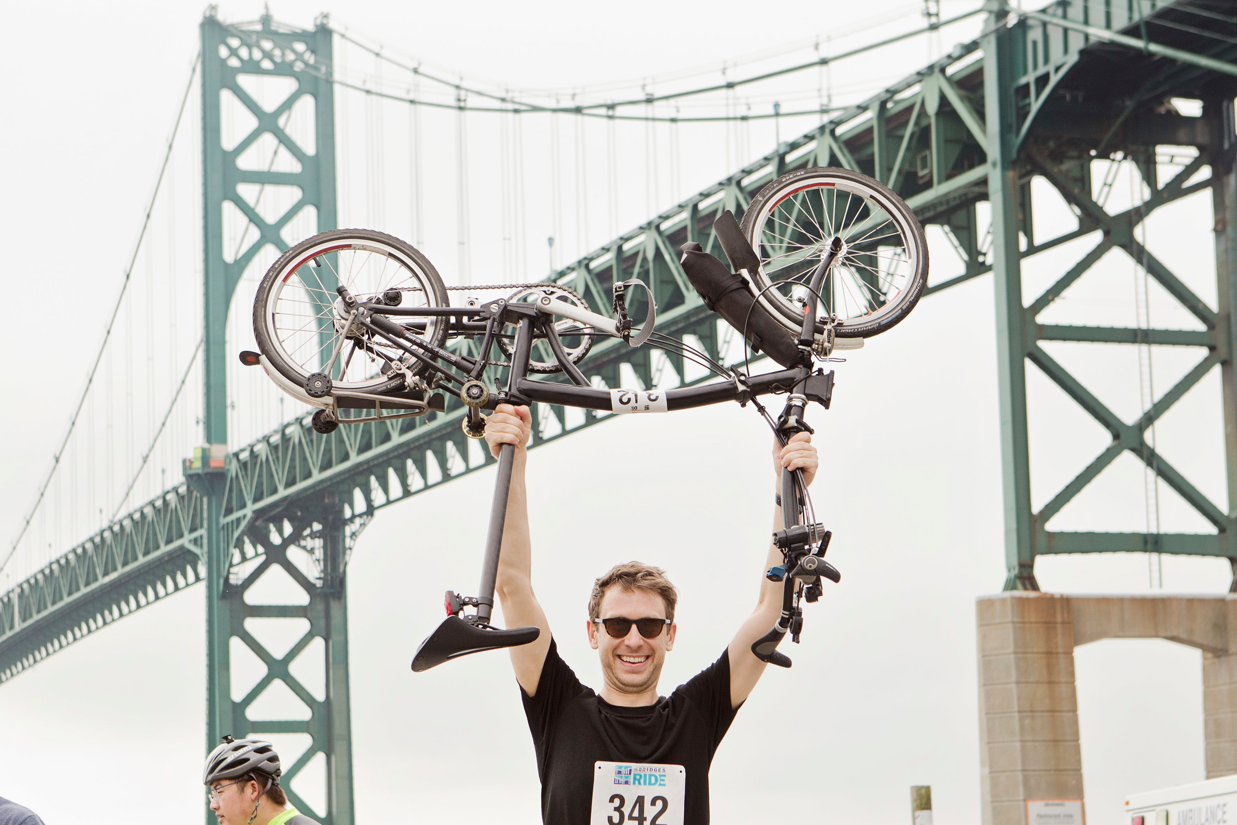 Alex Hanna of New York, N.Y. holds his bike up under the Mt. Hope Bridge in Bristol after completing the 26-mile 4 Bridges Ride. His father, Kim Hanna of Tiverton, also participated in the ride.