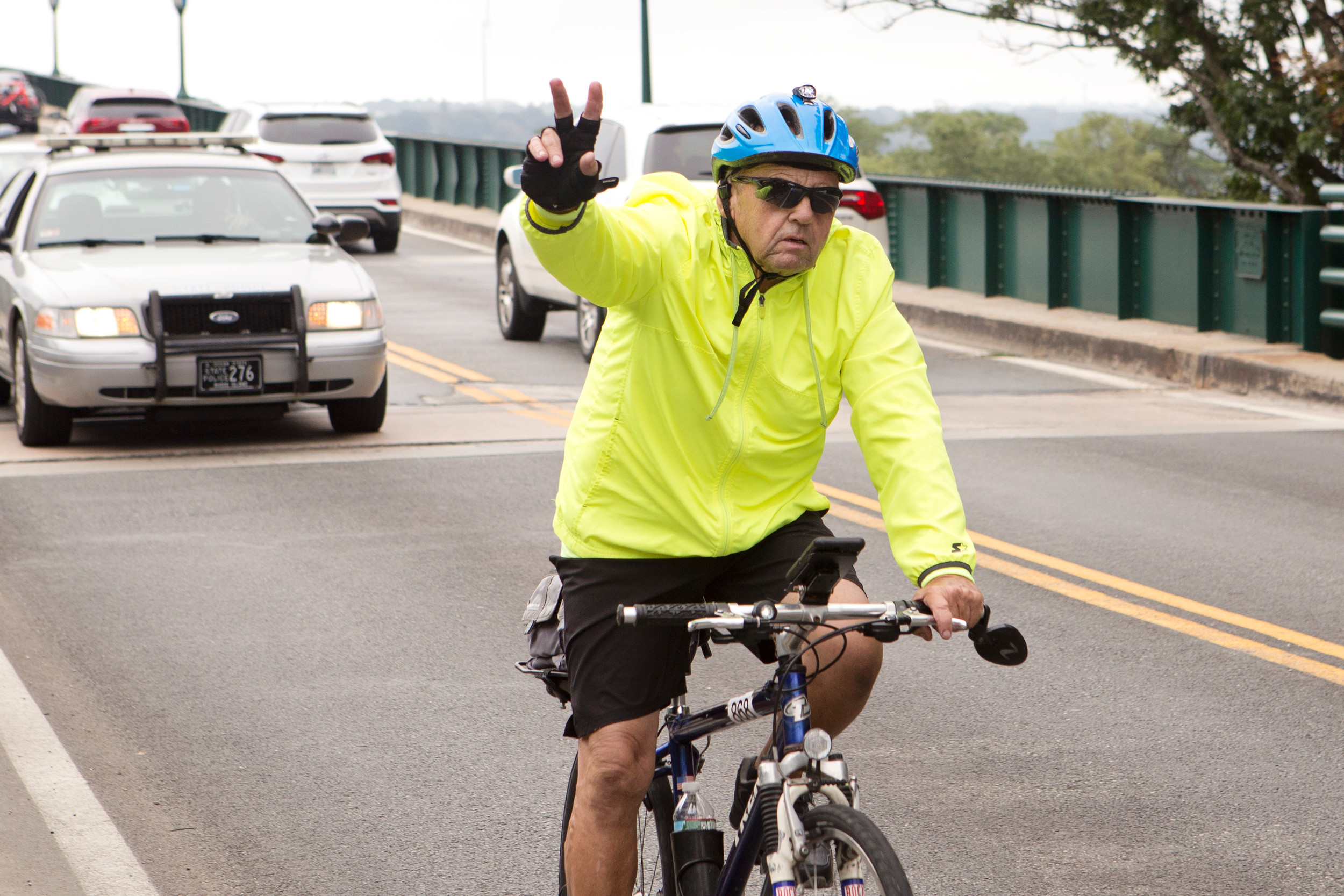 A rider flashes the peace sign as he completes the 4 Bridges Ride on the Bristol side of the Mt. Hope Bridge on Sunday.