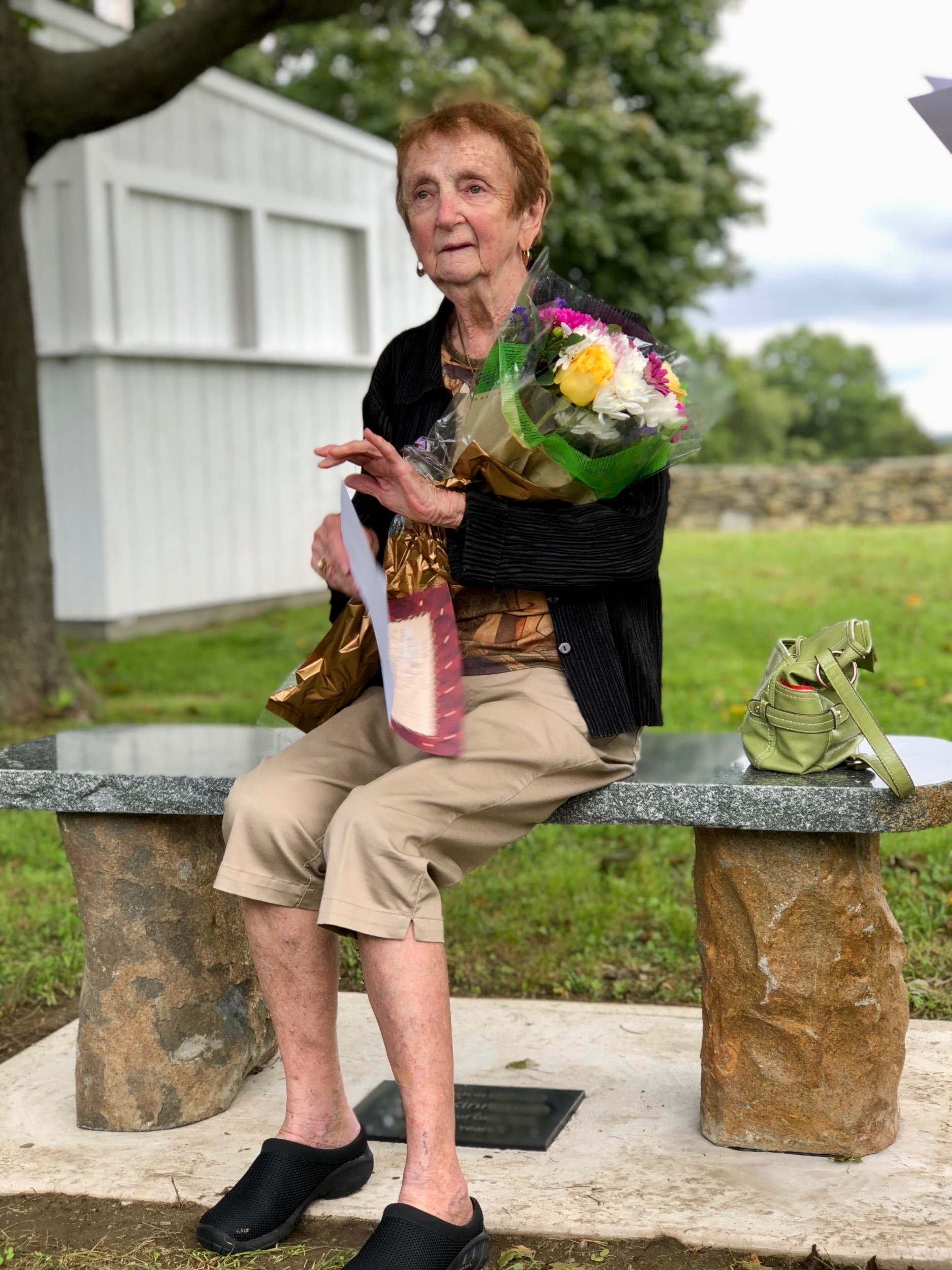 Grace Kinnunen sits on a bench that was dedicated in her honor during a ceremony at Glen Park on Thursday, Sept. 20. A plaque at its base calls Ms. Kinnunen a “champion of Glen Park for many years.”