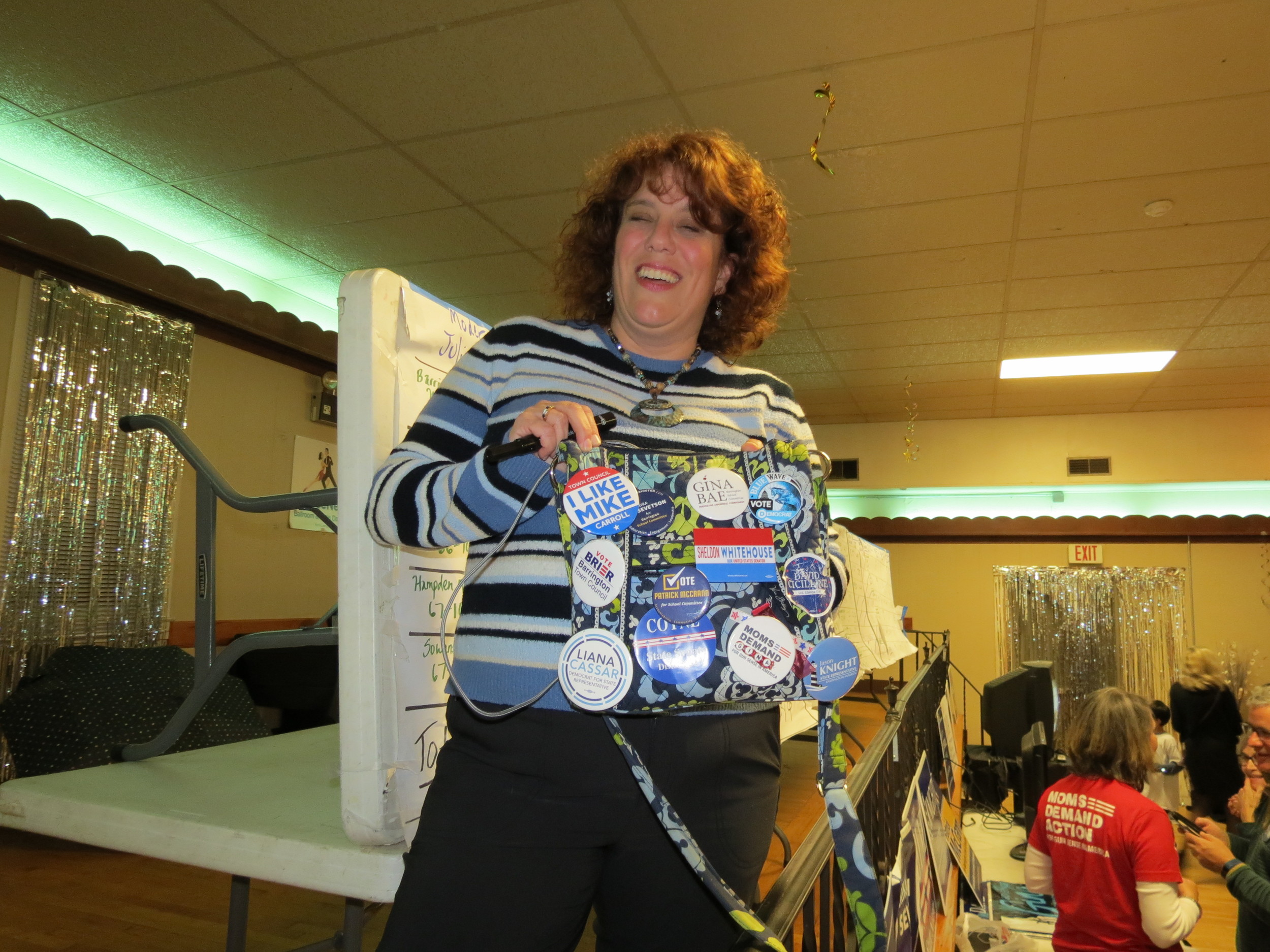 Pam Lauria, the chairwoman of the Barrington Democratic Town Committee, shows off her bag which is covered with Democratic candidates' campaign pins in this 2018 photo. Lauria is running for the District 32 seat in the RI Senate.