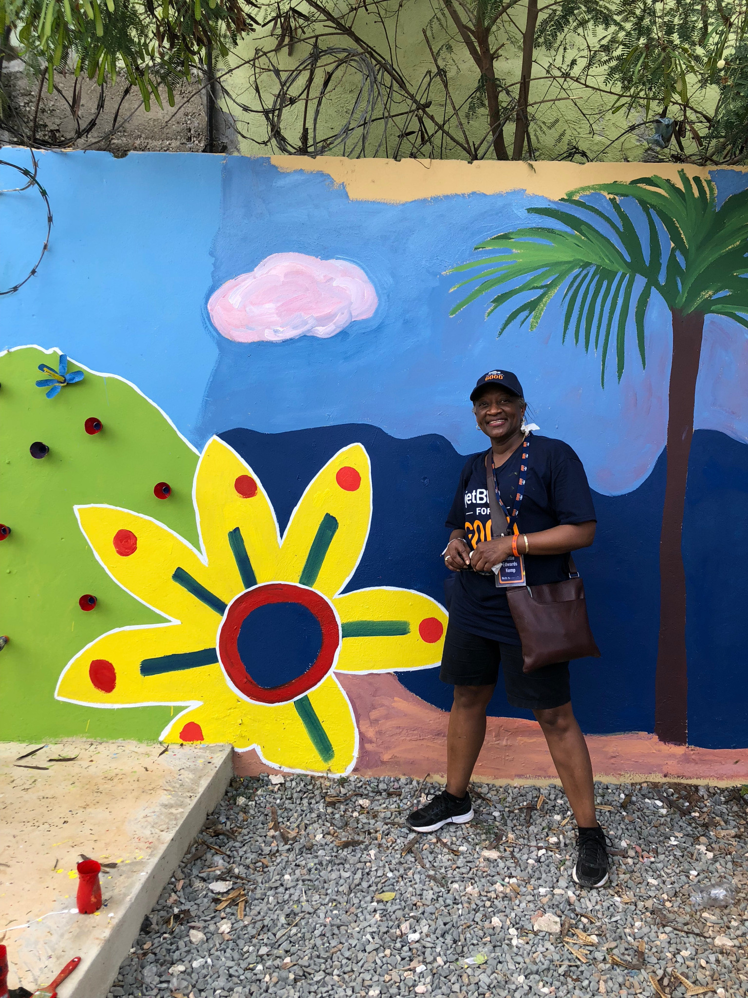 Mattie Kemp, associate head of school at Pennfield School, poses next to a mural that volunteers help create at a school in the Dominican Republic.