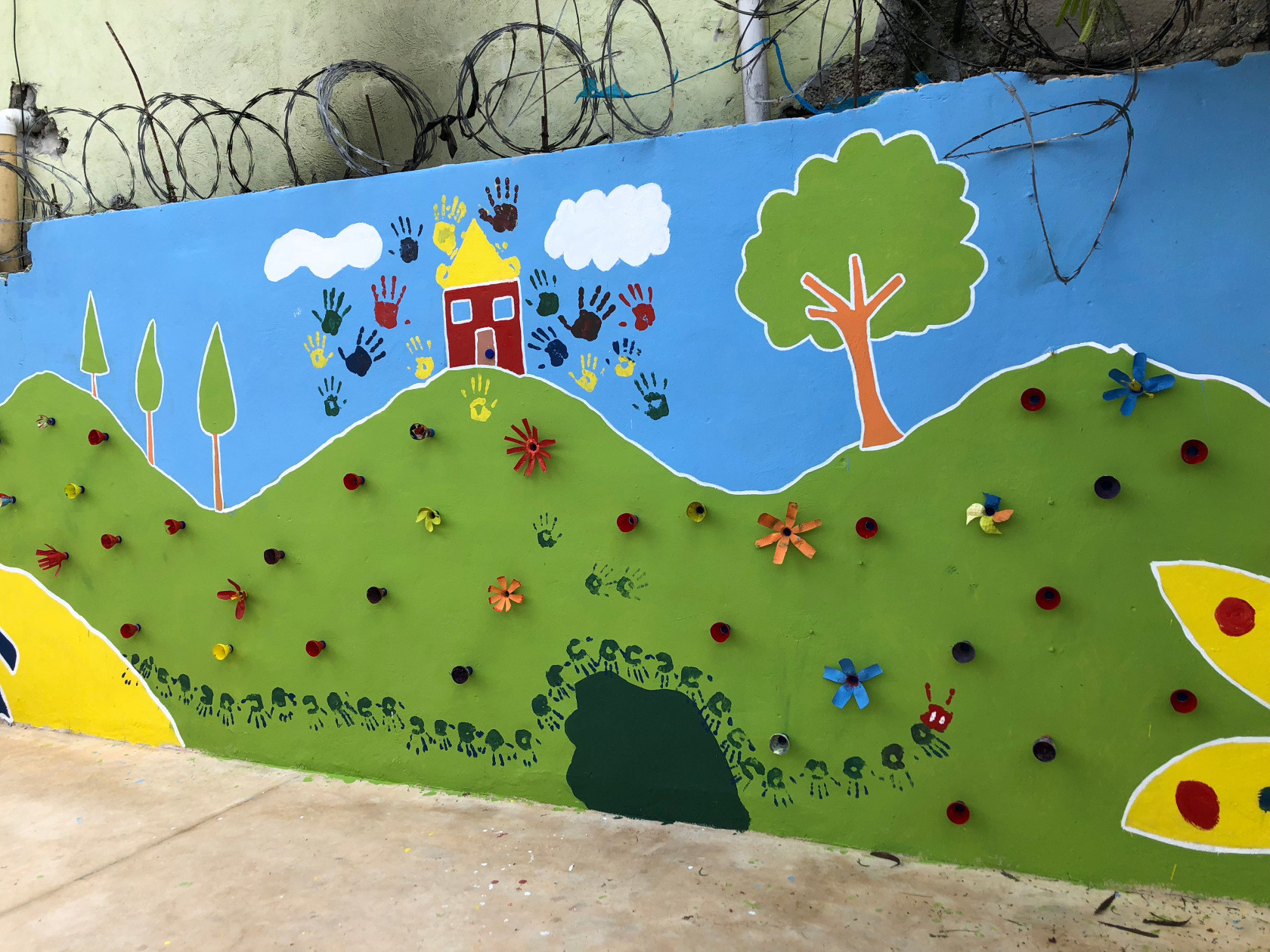 Volunteers used paint and recycled materials to create this mural outside a school in the Dominican Republic.
