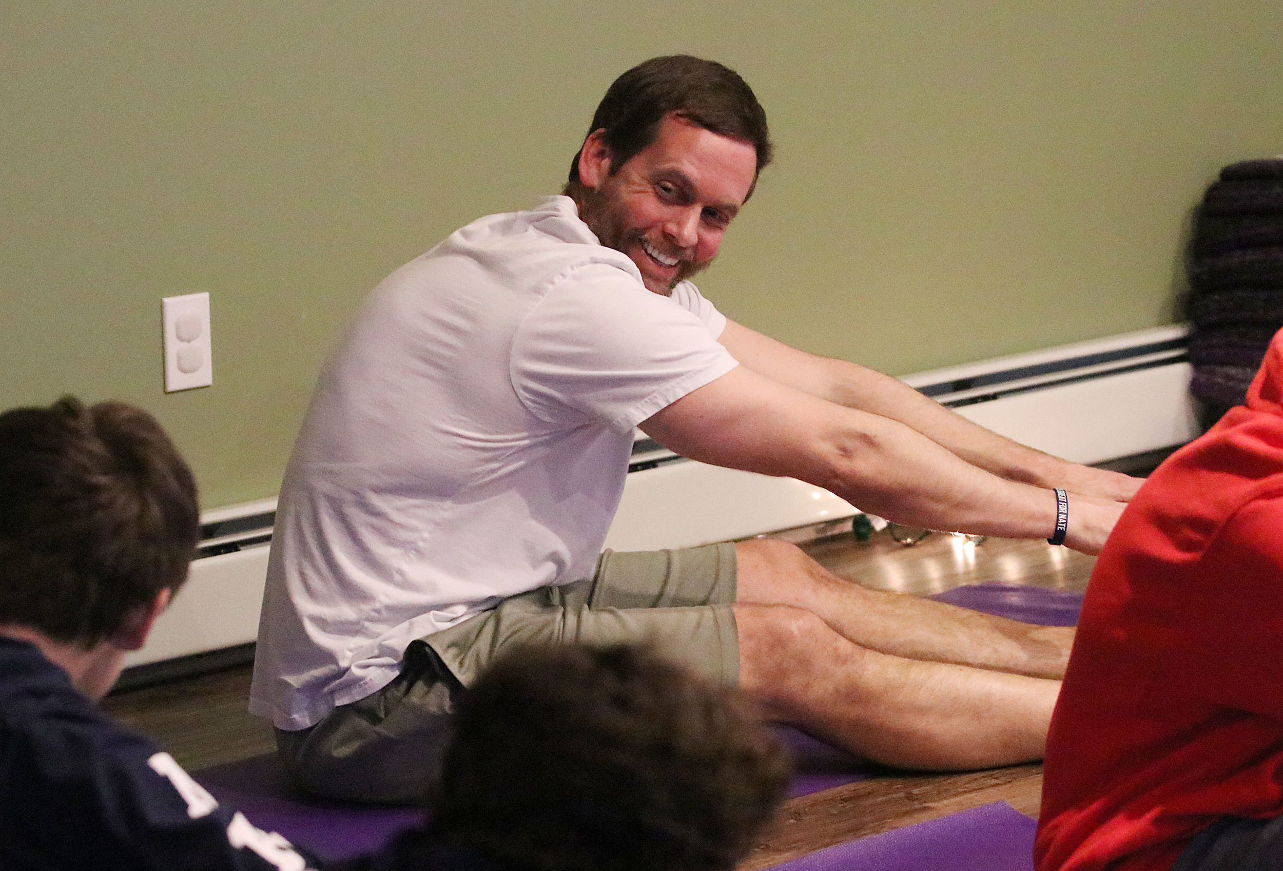 Rick Bruno, father of the late Nathan Bruno, laughs along with Nate’s friends during a yoga and mindfulness class at The Nest at Tenth Gate Yoga Saturday afternoon.