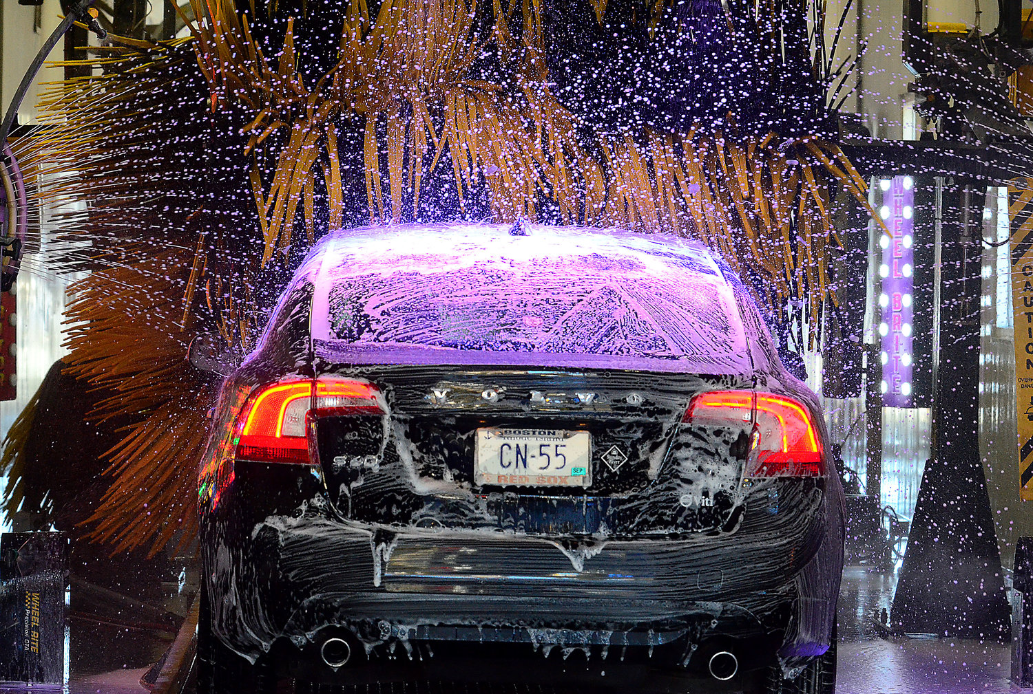 A car heads through the LustraShield surface gloss car wash into a series of brushes at the Blue Wave car wash on Friday.