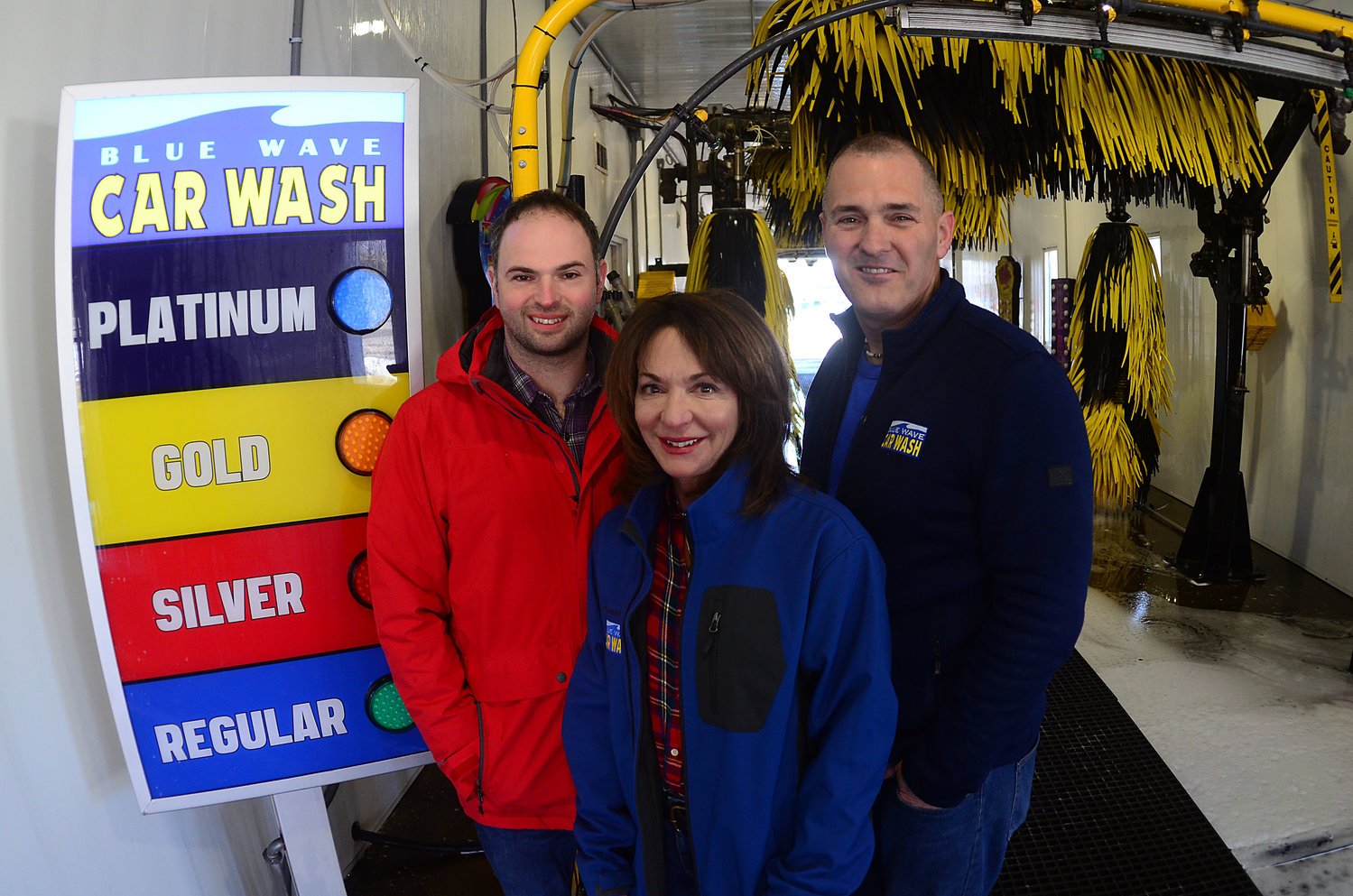 Blue Wave owner Yvonne Blackman (middle) poses with son David Blackman (left) and manager Pete Fabiano inside the car wash.