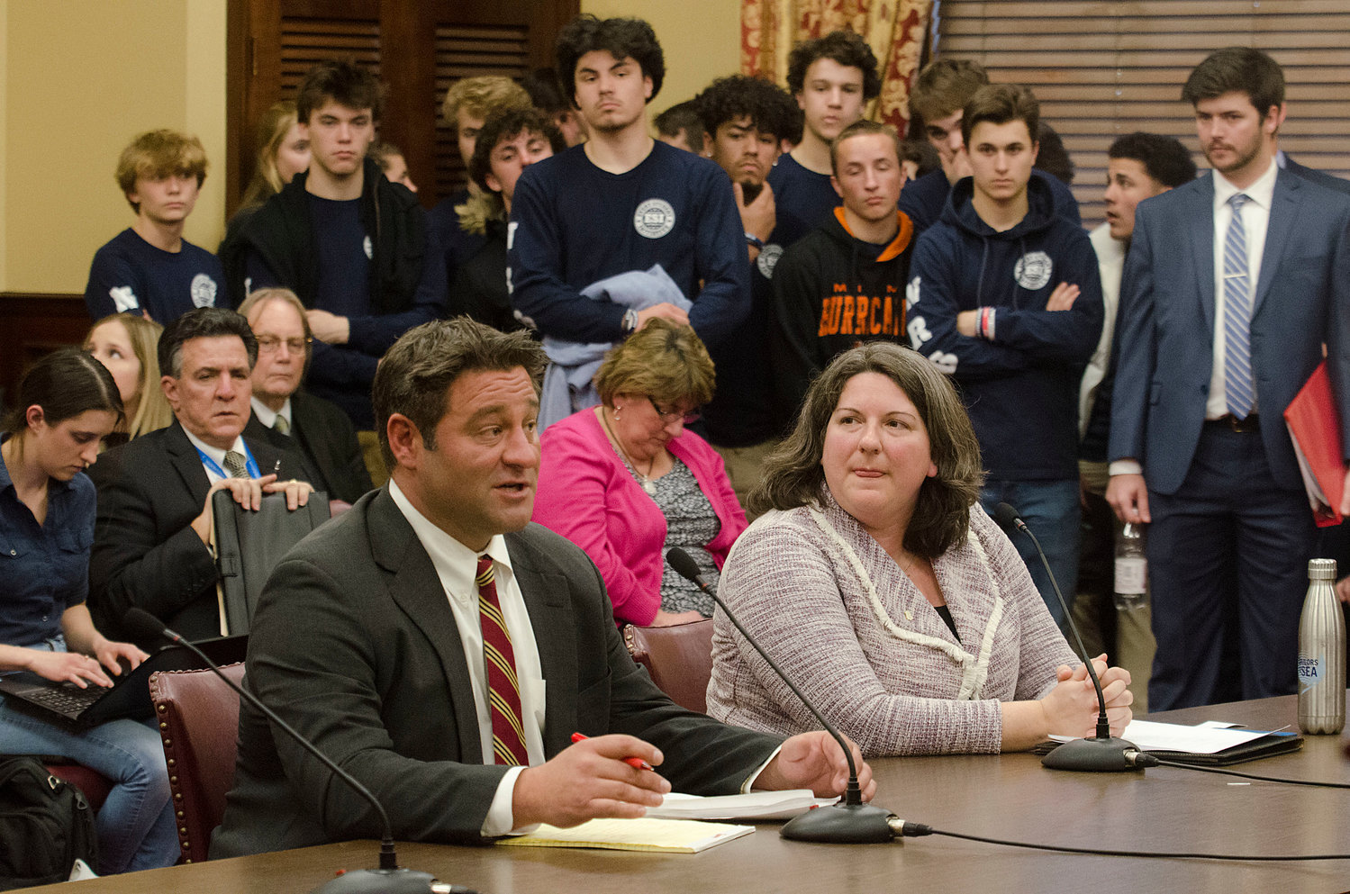Attorney Kevin Vendituoli testifies in favor of the bill as Sen. Dawn Euer, the measure’s main sponsor, looks on. Members of Every Student Initiative crowd a corner of the room behind them.