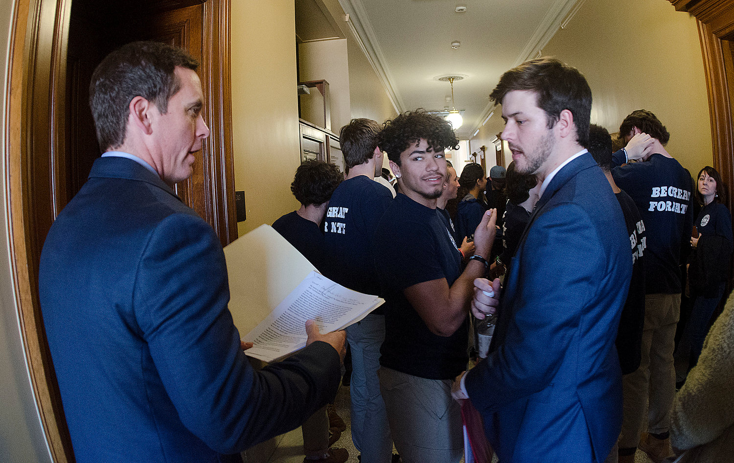 Rick Bruno (left), father of the late Nathan Bruno, speaks with Steven Peterson, program director of Every Student Initiative, outside a hearing room at the State House.