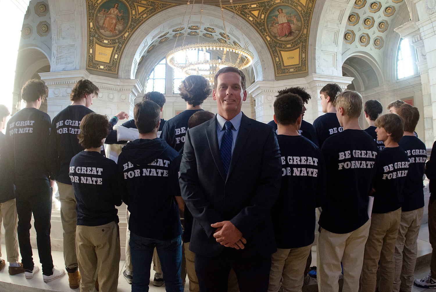 Rick Bruno poses with members of Every Student Initiative, who display the back of their T-shirts with a message in support of their late friend, Nathan Bruno.