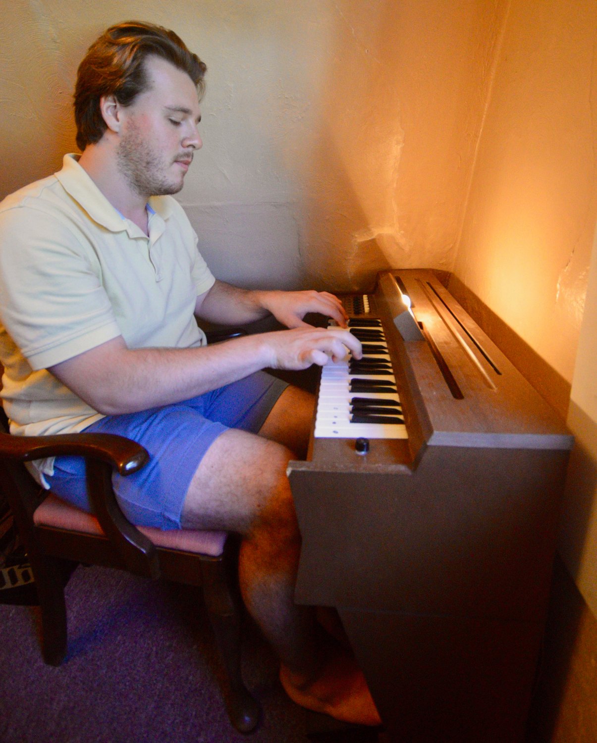 Nicholas Quigley, who teaches music to grades 5-8 at Atlantis Charter School in Fall River, plays a vintage chord organ at his Bristol Ferry Road apartment last week. The instrument, a smaller version of a regular organ, was popular in the ’60s and ’70s.