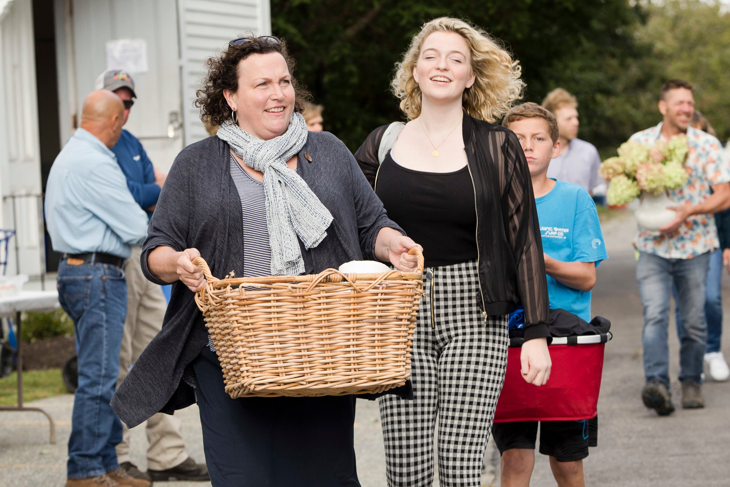 Victoria (left), Ursula, and James Talbot carry their meals toward a 
table as they arrive at Little Compton's second annual Community Dinner 
Sunday night.