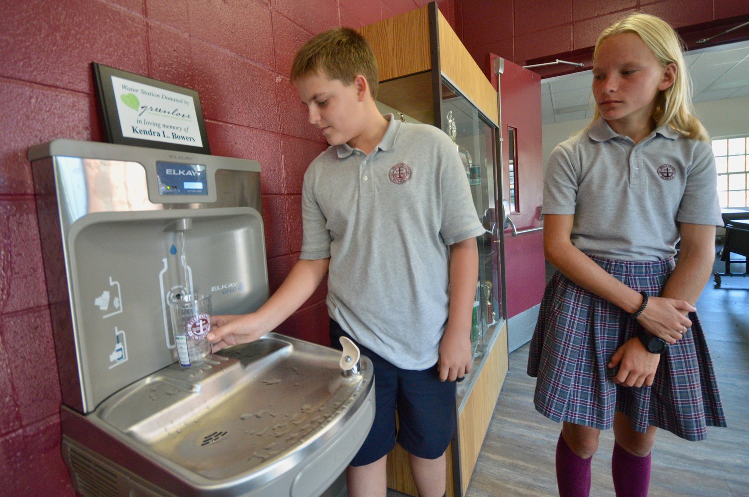 Chris DeSantis and Julia Pelczarski, both eighth-graders at St. Philomena School, try out the new water bottle filling station that was donated by the Greenlove Foundation.