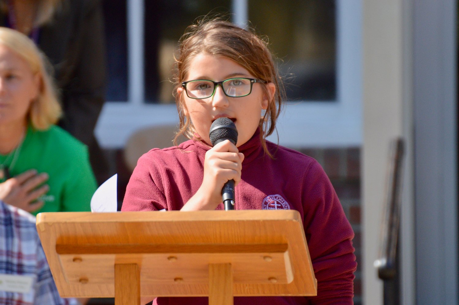 Lea Silvia, a sixth-grade student at St. Philomena School, sings The National Anthem at the start of Monday’s ceremony.