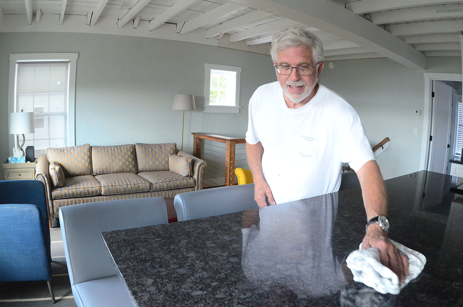 Tom Bergenholtz wipes down the countertop in a newly finished apartment at 211 Thames St.