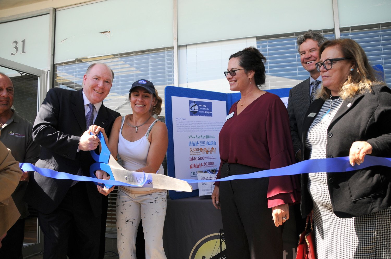 Thomas Joyce (second from left), East Bay Recovery Center director, helps with the cutting of the ribbon during ceremonies recently at the Railroad Avenue facility in Warren.