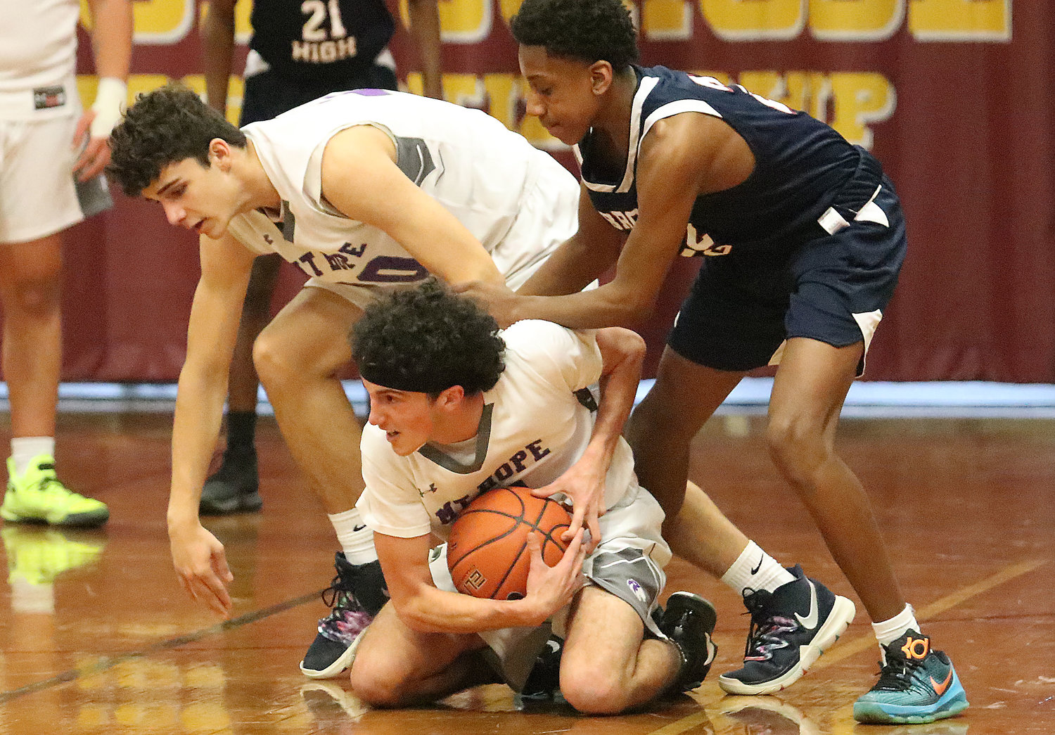 Brady Thibaudeau (left) catches himself from falling onto teammate Nuno Ponte-Amaral (center) as he collects a loose ball.
