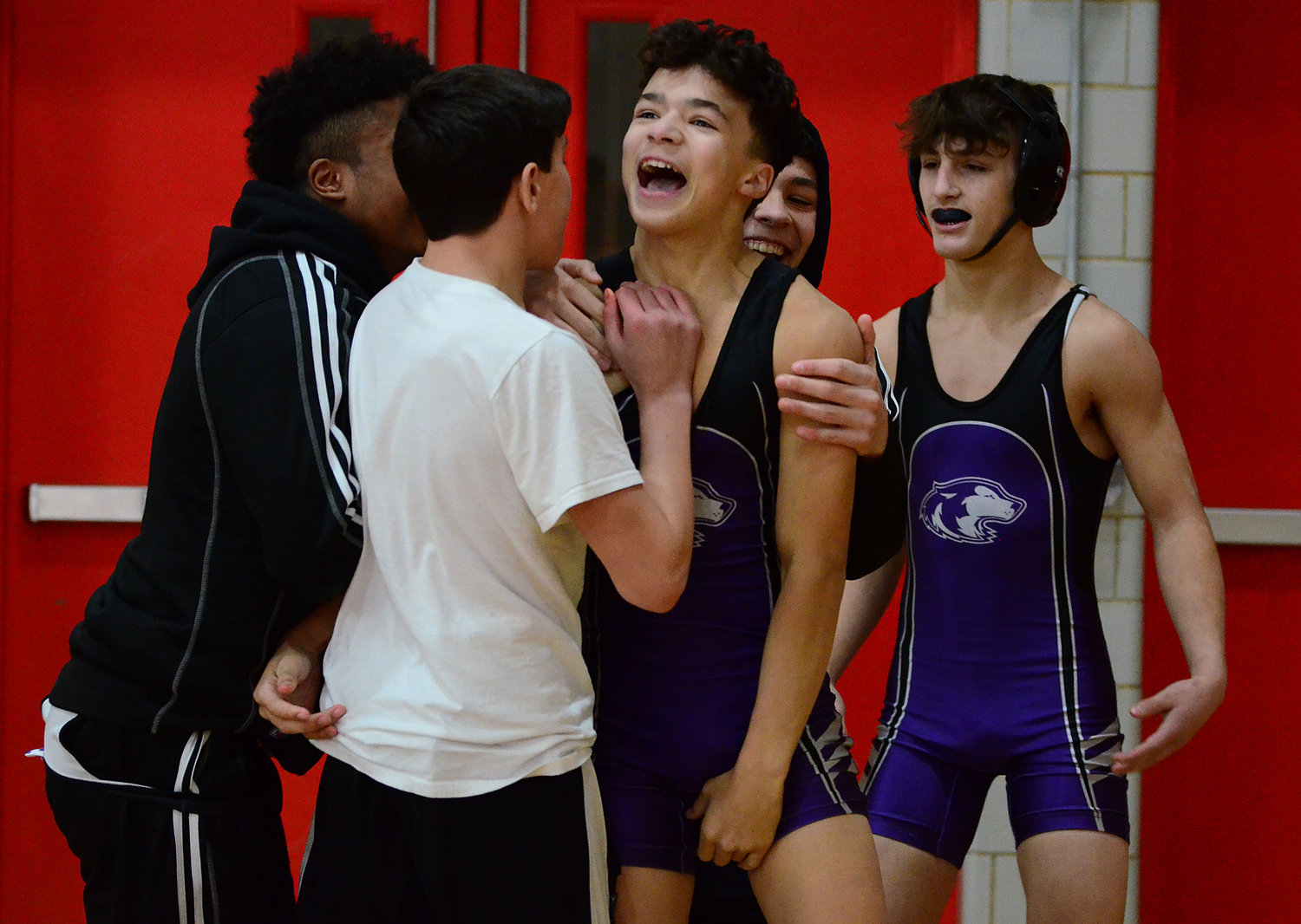 Teammates surround 120 pound Ethan Bland after he pinned Cumberland’s Zach Schonhoff during a quad meet at East Providence High School on Monday.