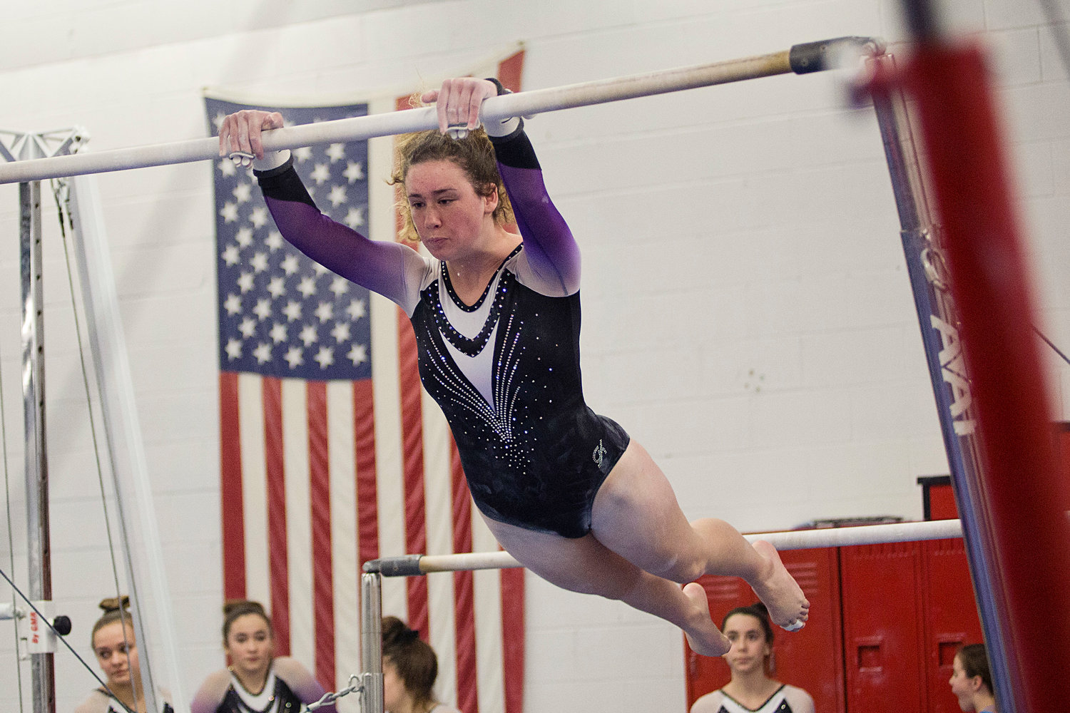 Senior Molly Thibaudeau extends to the high bar while performing
her routine during a home meet against South Kingston, Tuesday, January
21st.