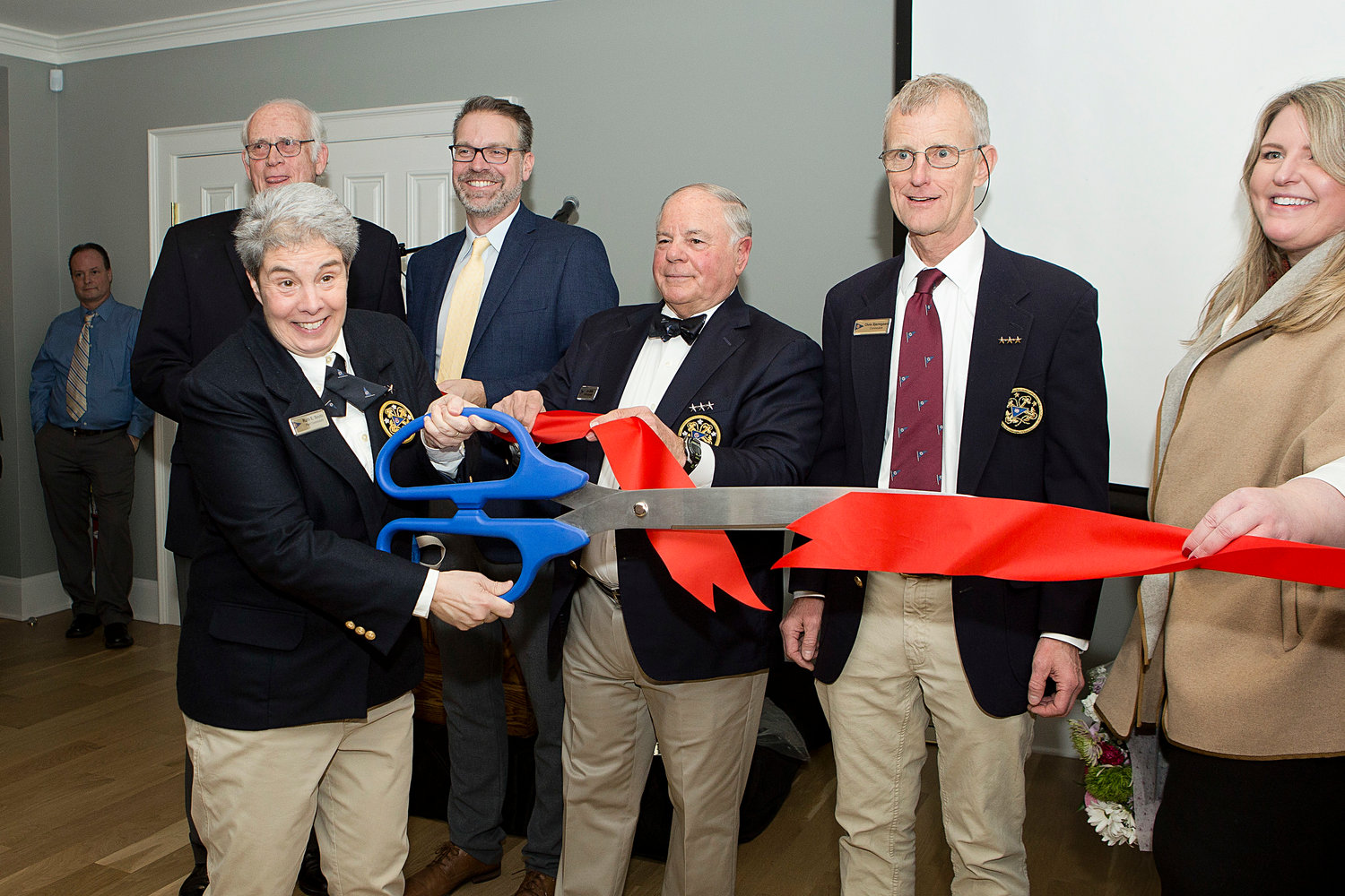 Commodore Ruth Souto clips a ceremonial ribbon, signaling the grand re-opening of the Bristol Yacht Club on Sunday.