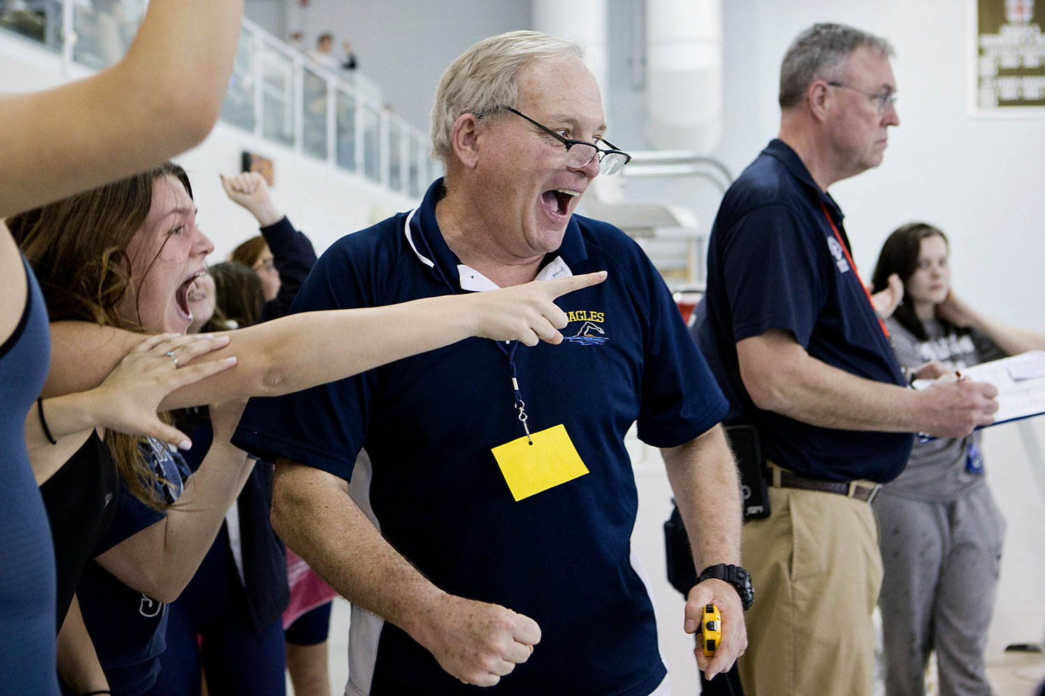 Barrington High School head coach Sandy Gorham reacts with his team as Sydni Diehl swims the final leg of the 400 free relay, securing the top spot at Saturday's State Championship meet.