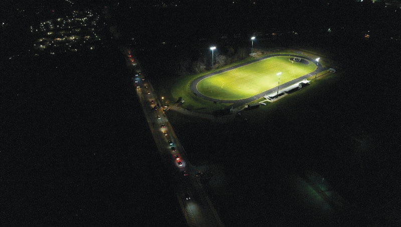 A drone shot of the Mt. Hope High School stadium Monday night shows the football field engulfed in light, plus a string of vehicles traveling up Chestnut Street.