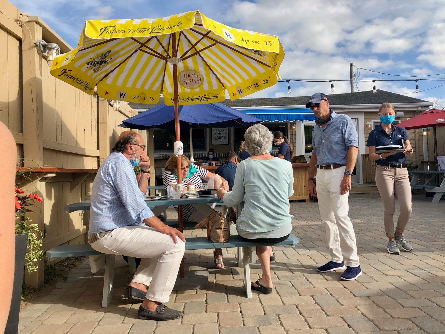 Mike MacFarlane (standing), owner of the new Blue Anchor Beer Garden on Park Avenue, makes the rounds during a sneak preview on Thursday, July 16. The outdoor beer garden is located behind his Blue Anchor restaurant, which has yet to open. Mr. MacFarlane also owns Tremblay's Island Park Bar & Grill next door.