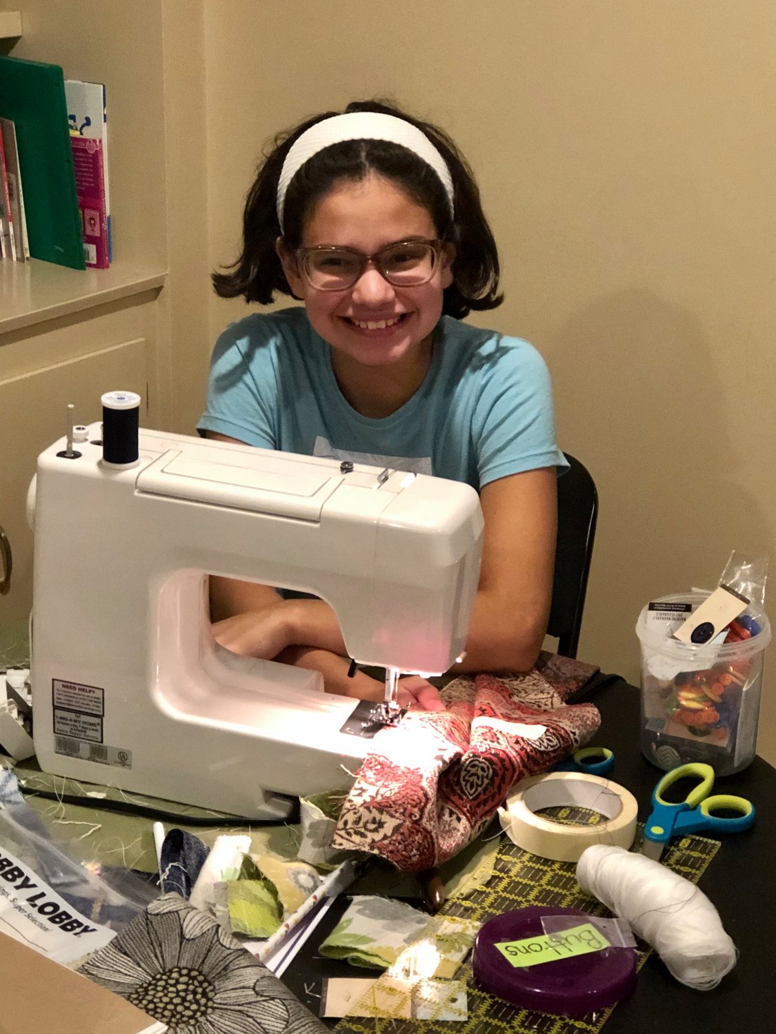Barrington's Lizzie Bahena takes a short break from sewing to pose for a photograph. Lizzie has been very busy these last few months making bags, purses and wristlets as part of a Confetti Kids fund-raiser.
