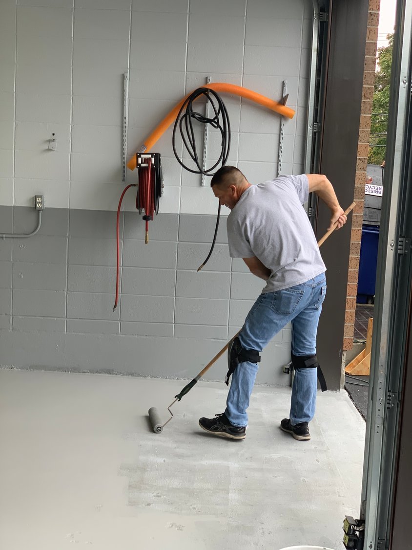Patrolman John Mlynek applies a new finish to a garage floor inside the newly refurbished Bristol Police Station. Two officers have been temporarily taken off the streets and assigned to make a host of building improvement.