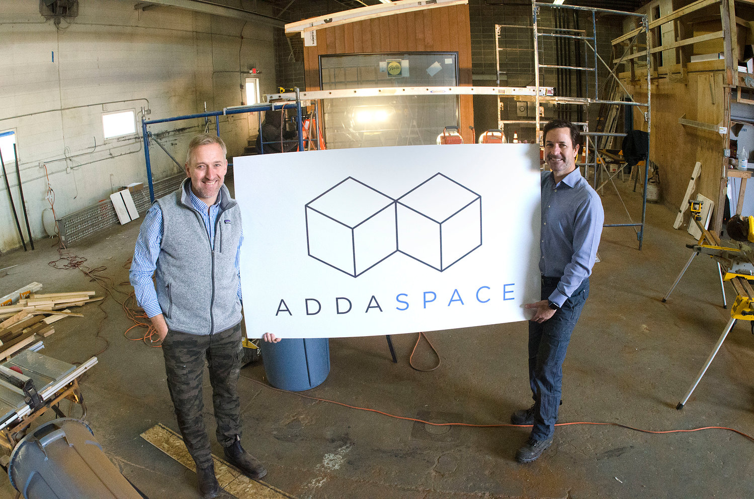 Anders Hansen (left) and Andrew Naperotic hold a company sign inside their Bristol facility. The two Barrington men started ADDASPACE earlier this year.