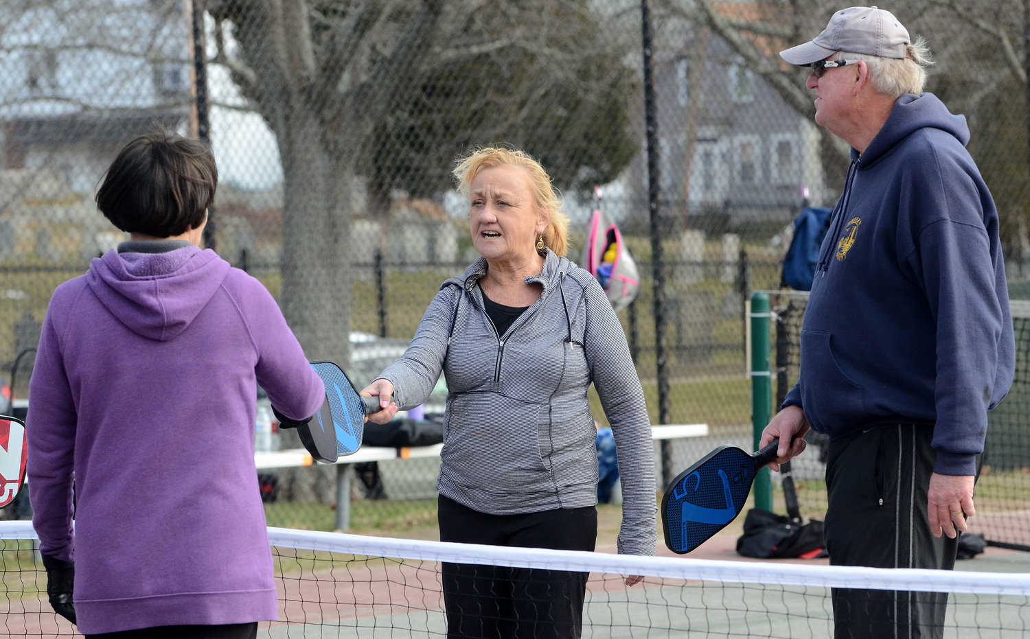 Eileen Malloy, Cathy Winston, David Schwartz and Peter Maloney (not in picture) touch racquets after the match. 