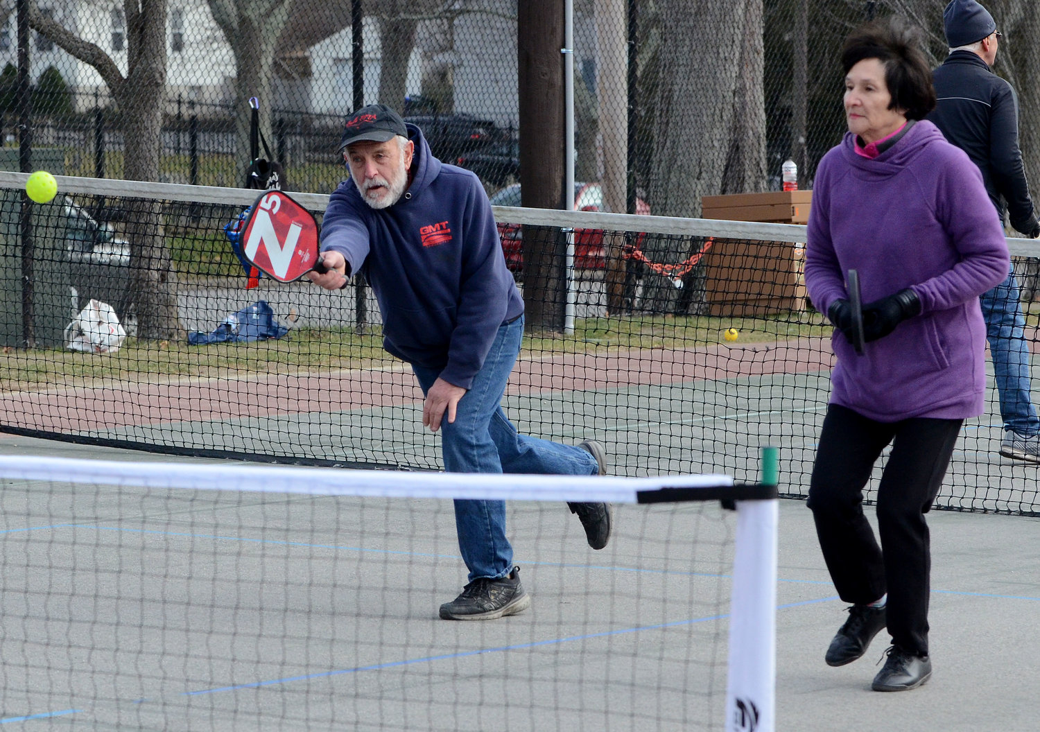 Paddle board teammates Peter Maloney and Eileen Malloy, both of Bristol, return the ball back over the net during a pickle ball match on the Town Common on Tuesday. 