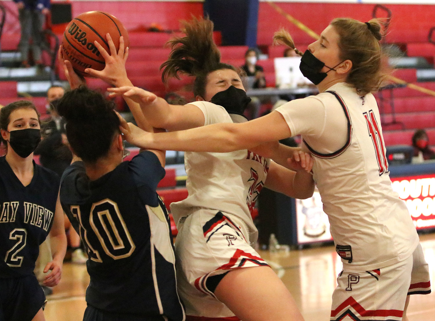 Patriots senior guard Emily Colicci (left) and Maeve Tullson vie for a rebound under the Portsmouth hoop.