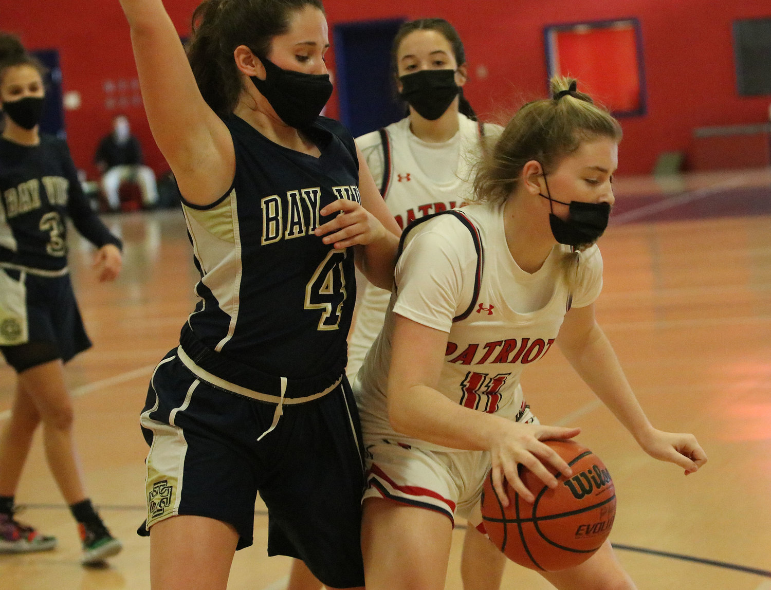 Patriots forward Maeve Tullson puts the ball on the floor in the offensive zone, with Olivia Durant looking on.