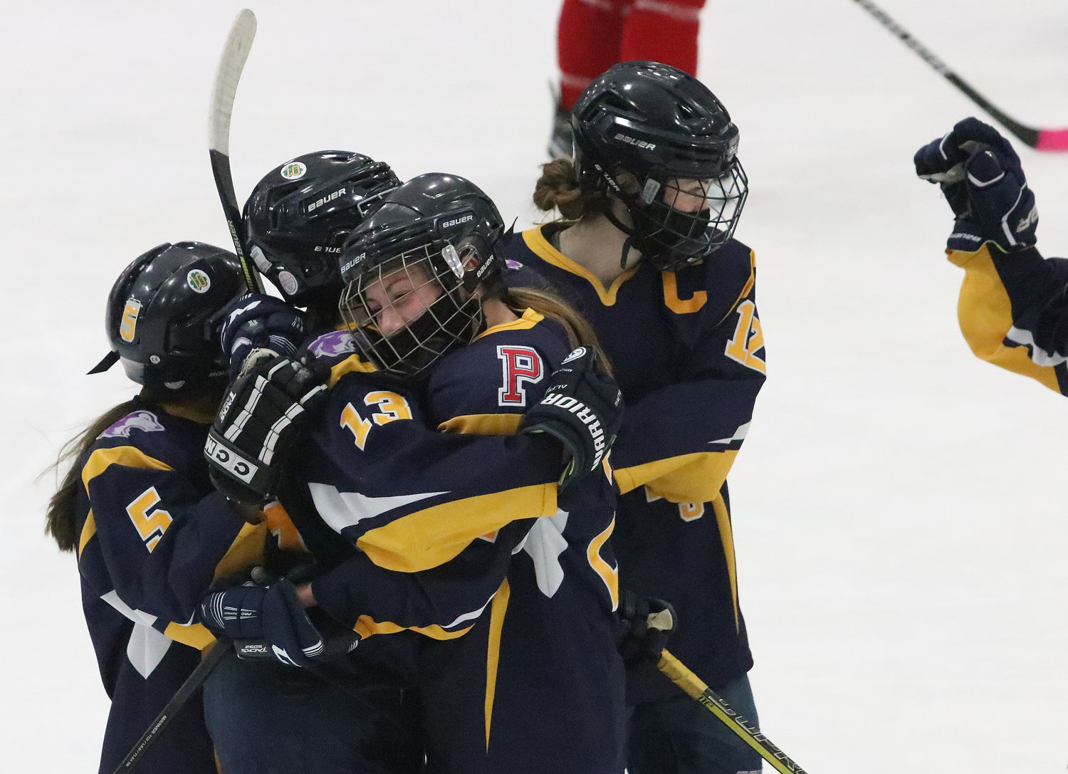 Samantha Yee (left), Sarah Yee and Kat Barker congratulate Alexandra Phelps after she scored on a shot from the point in the second period to give East Bay a 4-0 lead. 