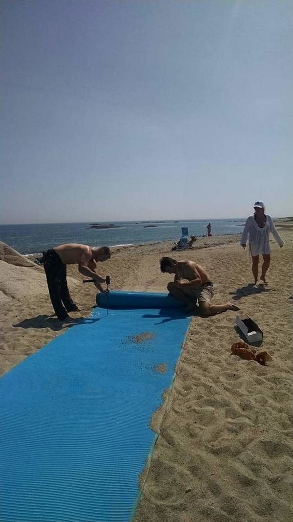 Volunteers install beach access mats at Knubble Beach in Westport over a year ago. The town’s Commission on Disabilities won selectmen support for new efforts to improve access to the beach and to those mats in this area of shifting sands.
