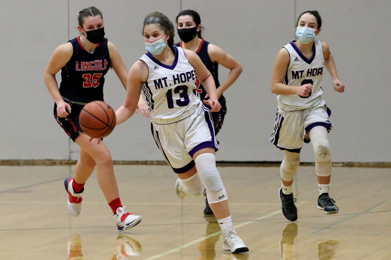Sophomore point guard Abby Razzino dribbles up court on a fast break in the third quarter with Isabel Savinon (right).