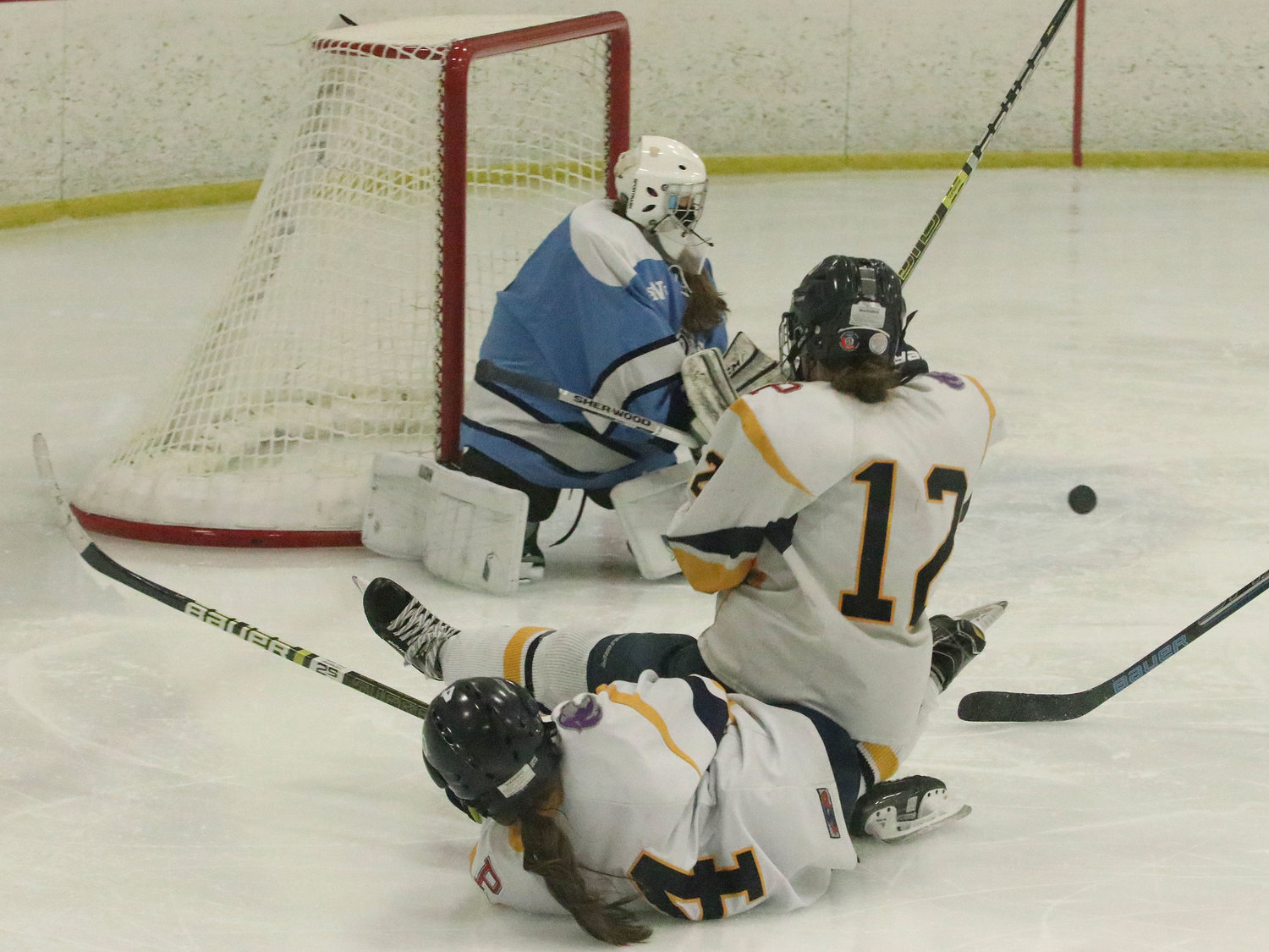 Forwards Marissa Levreault (left) and Kat Barker collide and slide away from the net after Barker got off a shot on goal in the waning moments of the third period of Game 2.
