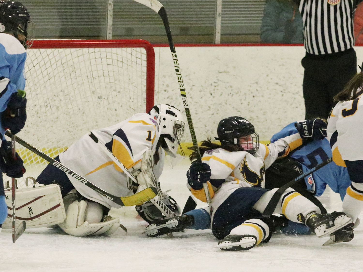 Goaltender Sara Turillo (left) and Malloy Cox slip to the ground attempting to keep the puck out of the East Bay goal in the third period of Game 2. Turillo was injured later in the game.