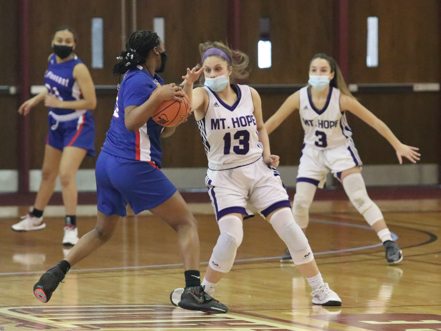 Sophomore guard Abby Razzino (left) checks a Mt. Pleasant guard as she dribbles up court with teammate Isabel Savinon (right).