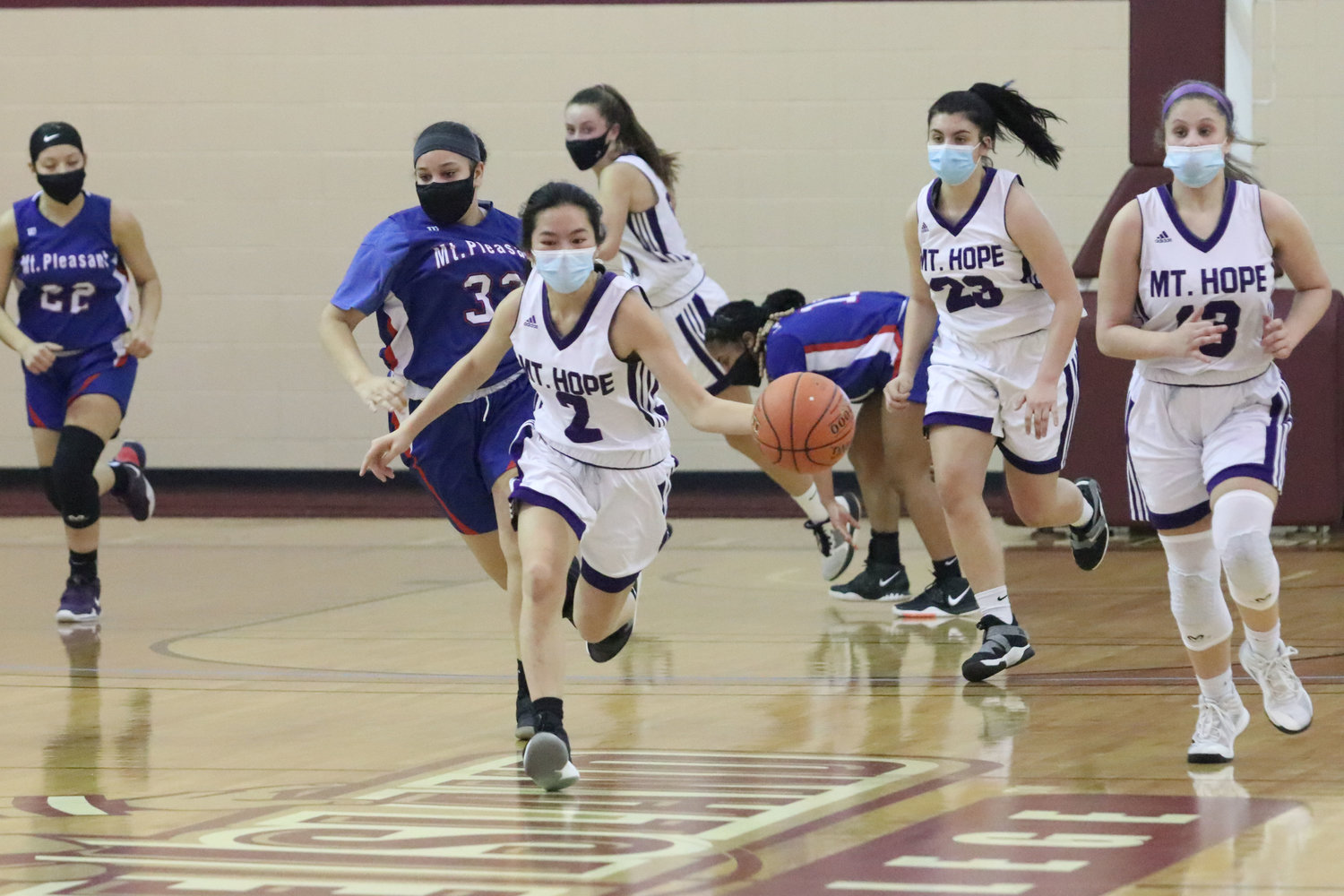 Elsa White (left) heads up court on a fast break after making a steal, with teammates Reyn Ferris, Aeryal Rodrigues and Abby Razzino.