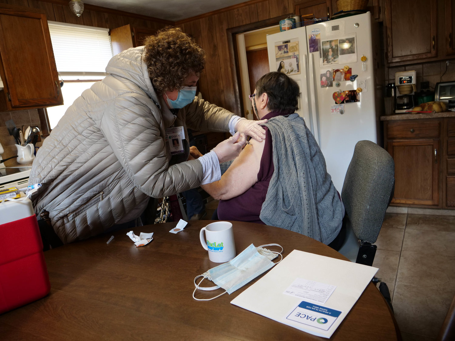 Nurse Lisa Pagliaro administers the vaccine to Prudence Island resident Rose Giarusso in her kitchen on Thursday.