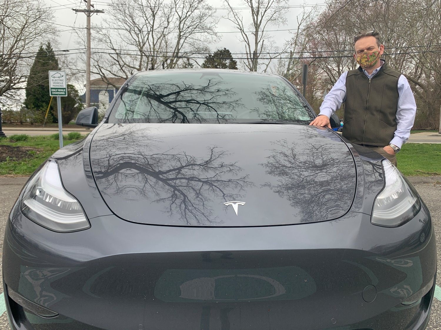 Barrington resident Magnus Thorsson stands next to his Tesla at Police Cove Park on Monday afternoon. Mr. Thorsson has submitted a proposal to the town, calling for the police department to use Teslas, an electric vehicle, instead of gas-powered vehicles.