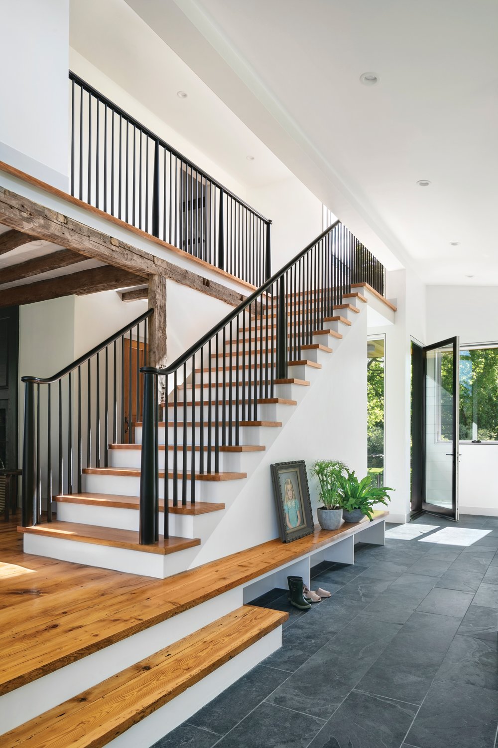 The entryway from the driveway into the home begins the transitions between modern and historic. Note that the primary level of the home actually becomes a convenient bench as it extends toward the door.