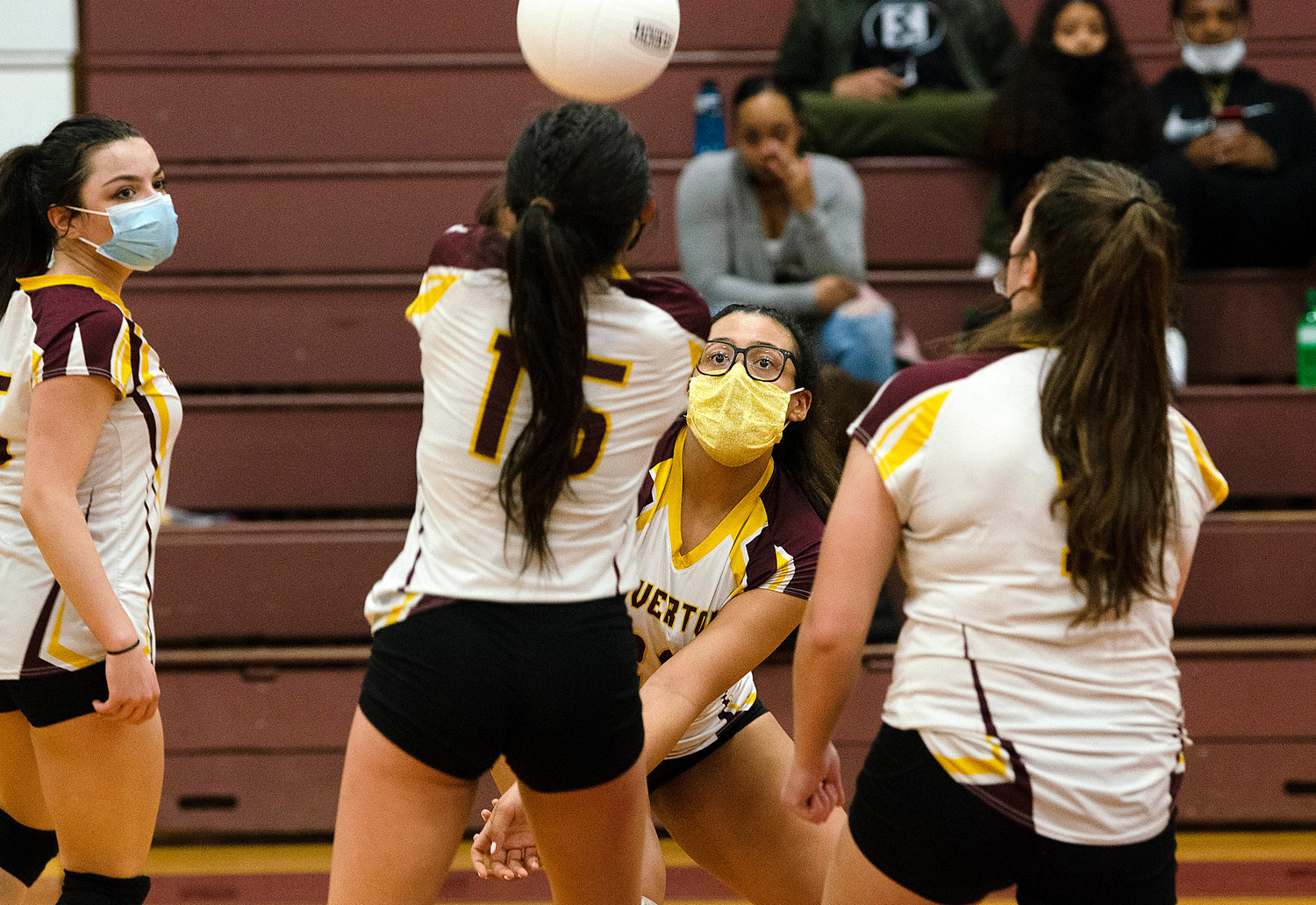 Teammates look on as Kaylie Cabral (mid-left) and Olivia Miranda vie for the ball.