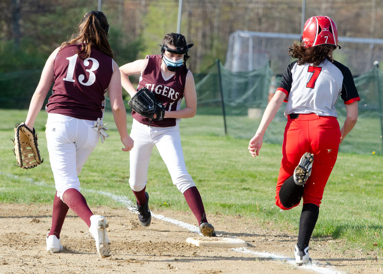 Michaela Andrews steps on first base for an out. Abigail Monkevicz looks on (left).