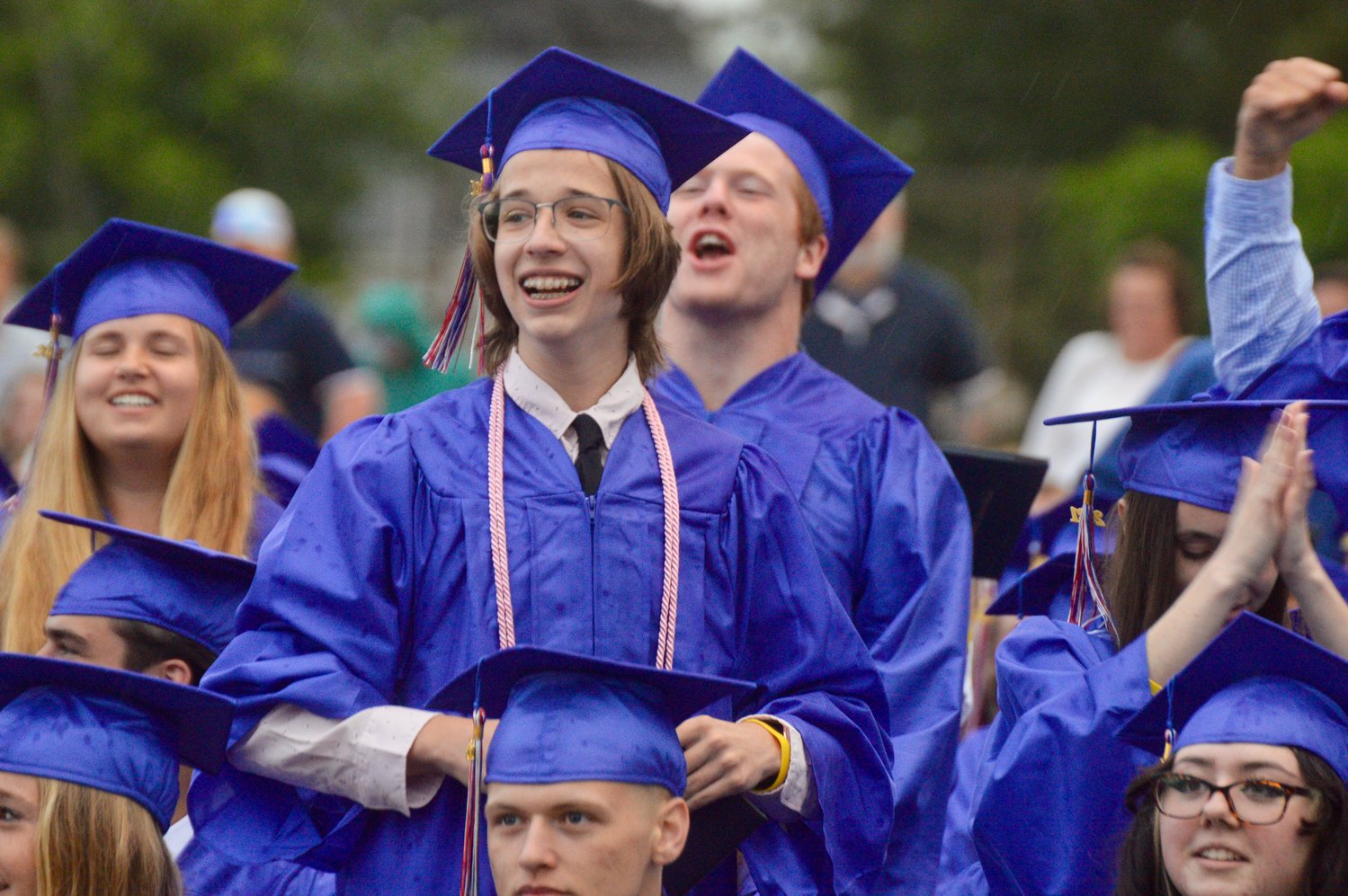 Julien Turner (front) and Samuel Steen cheer on other graduates after having received their diplomas.