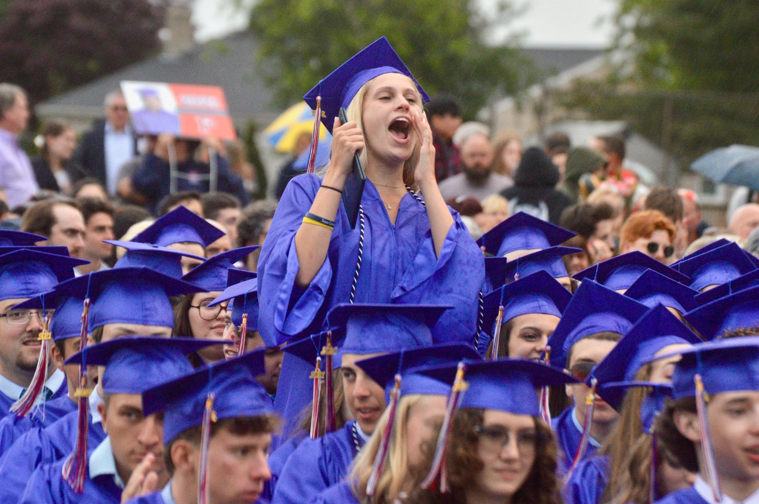Juliana DeComo gives a shout-out to a fellow grad collecting a diploma.