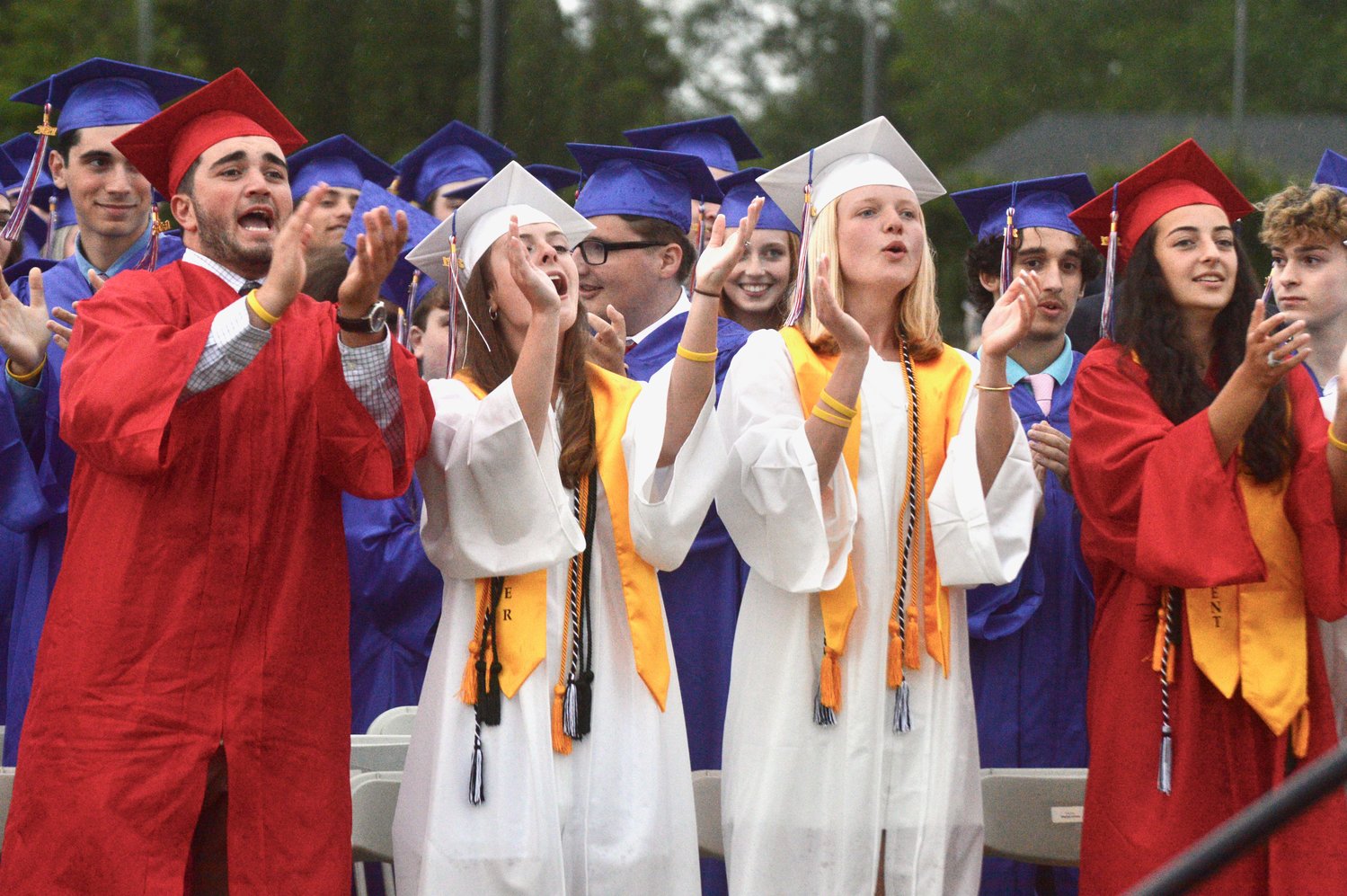 Michael Nardolillo, Megan Buddemeyer, Ellen Stack and Meghan Lehane (from left) cheer on fellow graduates as they were receiving their diplomas at Friday night’s commencement ceremony on the Portsmouth High School baseball field.