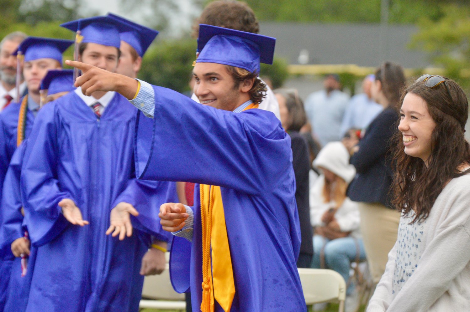 Sam Stamoulis points to the stage before walking up to collect his diploma.
